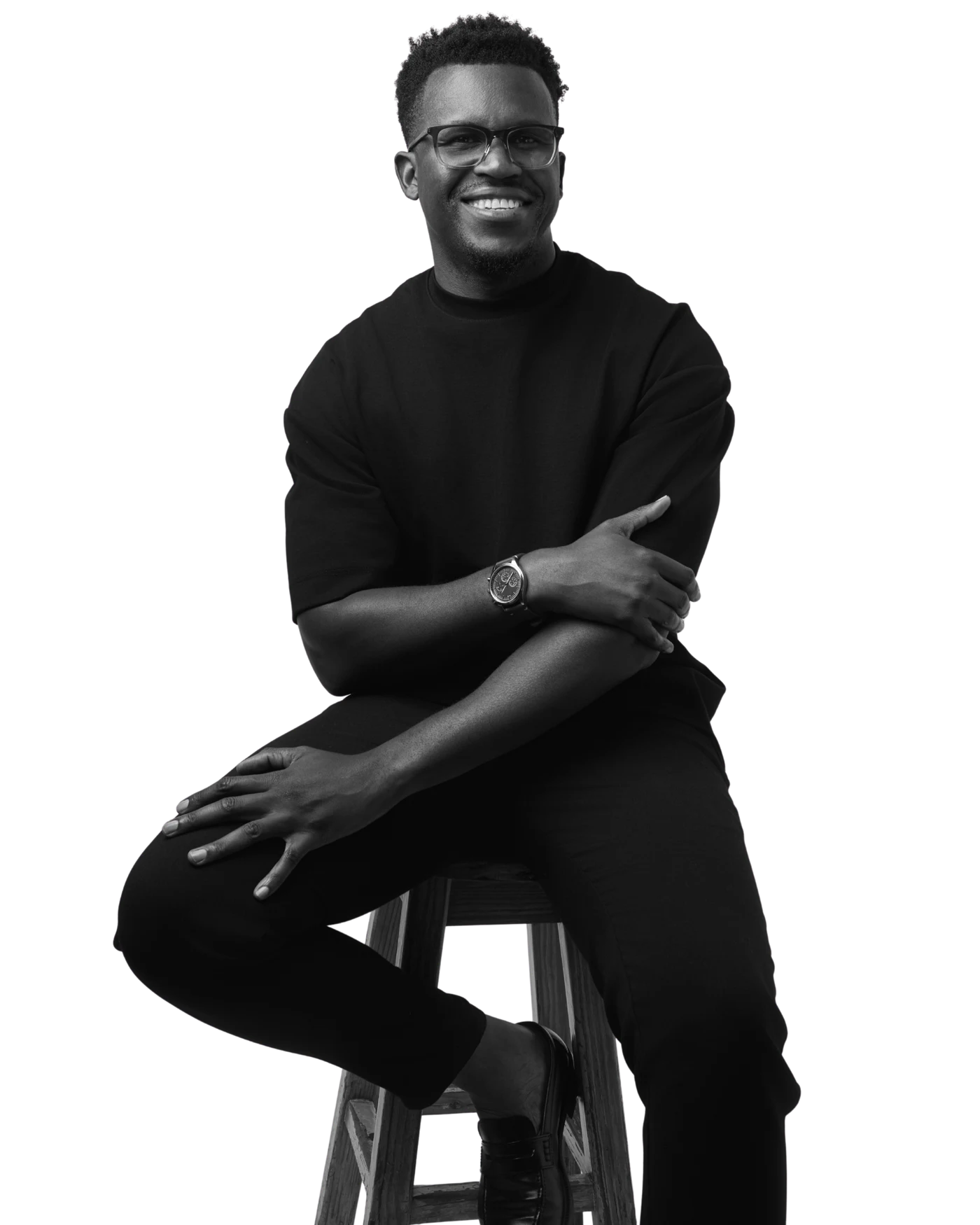Phinius smiling, seated on a stool.