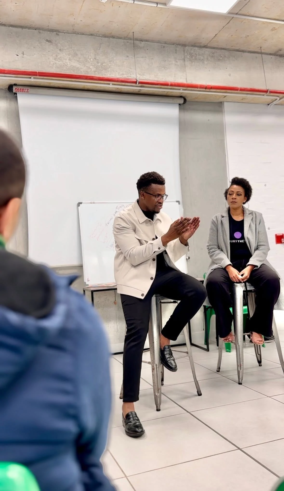 Phinius and another participant in a seated conversation with microphones.
