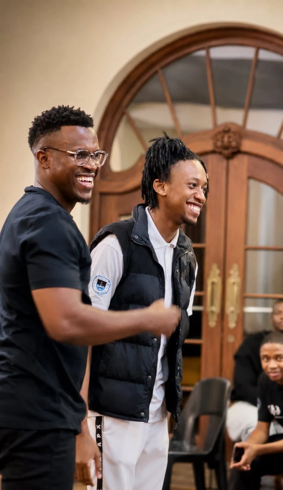 Phinius smiling alongside a companion at a gathering.